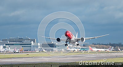 A Norwegian Airlines plane takes off from London Gatwick Airport, with jet wash w Editorial Stock Photo